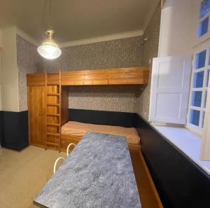 Zimmer mit einem Tisch und einem Etagenbett in der Unterkunft Appart COQUET Intra-Muros façade historique rez de chaussée terrasse in Saint-Malo