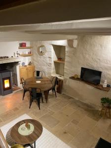 a living room with a table and a fireplace at Maison authentique in Flavigny-sur-Ozerain