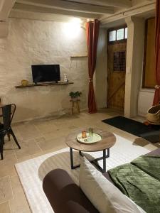 a living room with a table and a tv at Maison authentique in Flavigny-sur-Ozerain