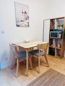 a wooden table and chairs in a living room at Un appartement en centre ville , à 2 pas du château de Villers Cotterets in Villers-Cotterêts +4 photos