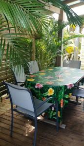 a table with flowers on it on a patio at Bungalows MALUEVA PREMIUM 1 chambre et 1 mezzanine à 5min de la plage de la Caravelle in Sainte-Anne