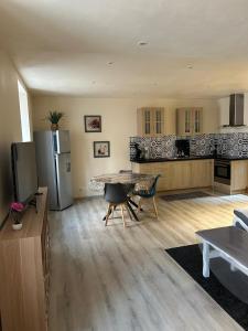 a large kitchen with a table and a refrigerator at T2 BOURGEAT - Charmant 2 pièces - Centre ville in Bourg-Saint-Maurice