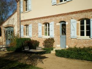 ein Backsteingebäude mit einem Tisch davor in der Unterkunft L'Oustal du Lauragais in Labastide-Beauvoir