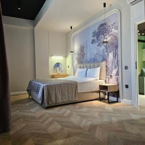 バクーにあるLuxury City Apart Hotelのベッドと壁に絵が飾られた寝室