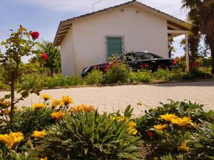 a car parked in front of a house with flowers at Bungalow bei Emma in Cavallino-Treporti