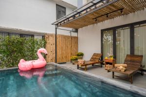 a pink inflatable swan in a swimming pool at Happy Villa Hoi An in Hoi An