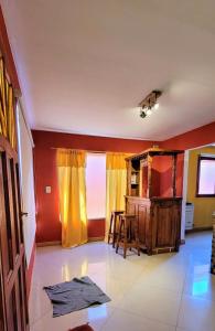 a living room with red walls and a kitchen with a table at El descanso in Los Antiguos