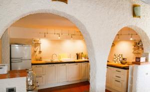 a kitchen with white cabinets and an arched doorway at Cool Natural Relax at Alivé Home&Garden in Sassello