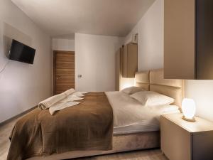 Un dormitorio con una cama y un televisor en la pared. en Sunway - Pool & Spa Beach Resort, en Mamaia Nord – Năvodari