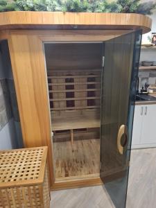 a large wooden cabinet with a glass door in a kitchen at Šermukšnis in Rokiškis