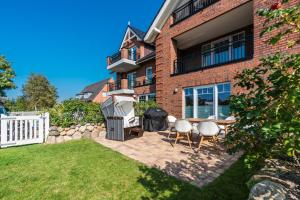 a backyard with a table and chairs in front of a building at KÖ-Gartensuite in Westerland
