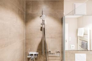 a shower with a glass door in a bathroom at KÖ-Gartensuite in Westerland