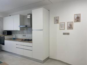 a kitchen with white cabinets and a refrigerator at Dream Suite Bologna in Bologna