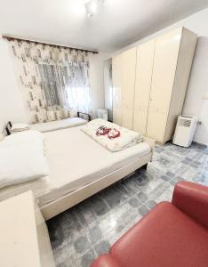 a bedroom with two beds and a red chair at D Friendship Apartment in Shkodër