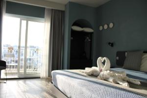 a bedroom with a bed with two white swans on it at Victoria by Petit Chic in Mellieħa