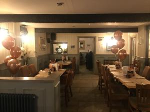 a restaurant with balloons on the walls and tables at Old Sun Inn in Haworth