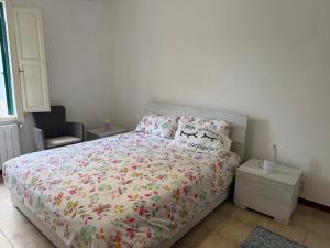 a bedroom with a bed with a floral bedspread and pillows at Villino La Perla Marina in Marina di Pisa