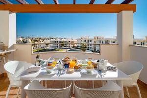 a table with food and drinks on a balcony with a view at Lagos Ocean View 2 With Pool by Homing in Lagos