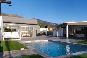 a villa with a swimming pool in front of a house at JVG VILLAS - Villa Giulia in Güimar