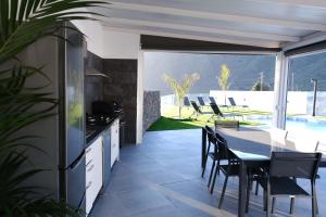 a kitchen with a table and chairs on a patio at JVG VILLAS - Villa Giulia in Güimar