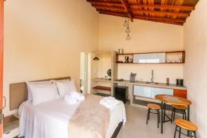 a bedroom with a bed and a kitchen at Refúgio das Serras in Cunha