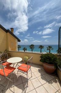 Un patio con mesa y sillas y el mar. en Guest House Bike & Relax Finale Ligure, en Finale Ligure