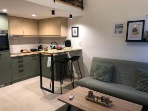 a living room with a couch and a kitchen at Be my guest in Xylokastro
