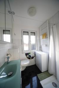 a white bathroom with a sink and a toilet at Apartment Walküre in Bayreuth