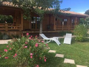 una casa con dos sillas blancas en el patio en Le chalet de Kiki, en Le Verdon-sur-Mer 16 fotos más