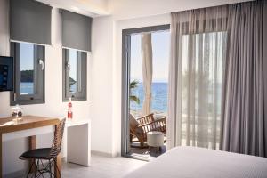 a hotel room with a bed and a desk and a window at Icon Suites by the sea in Potos
