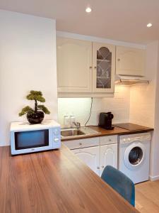 a kitchen with a microwave and a bonsai on a table at Claelle Appartment - 200m beach in Mandelieu-La Napoule +43 photos