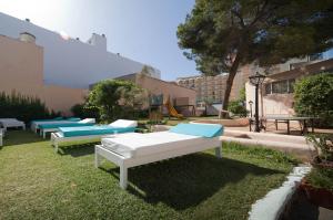 a row of beds sitting in the grass at Hotel Vibra Marco Polo I - Adults only in San Antonio