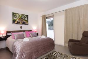 a bedroom with a bed and a chair and a window at Fantástica Casa Adosada con Piscina y Parking in Mojácar +41 photos
