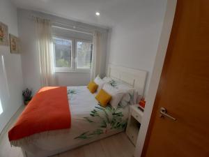 a bedroom with a bed with an orange blanket at AGRO da FONTE- Apartamento in Muros