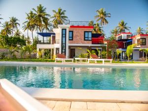 a house with a swimming pool in front of a house at Ndovu Villas Limited in Watamu