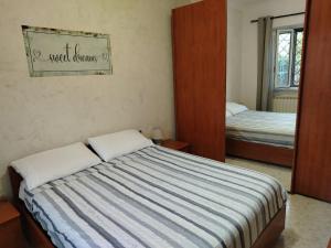 a bedroom with a bed with a striped comforter at A Casa di MiVa in Santa Maria delle Mole