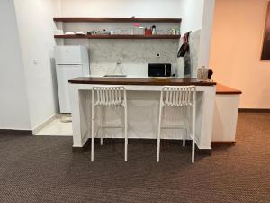 a kitchen with two stools at a kitchen island at Prestige Dakar in Ouakam