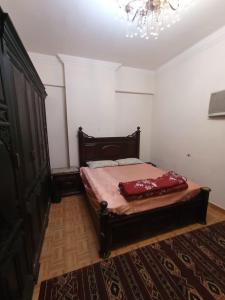 a bedroom with a bed and a chandelier at عماره 7 ج in Cairo