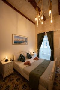 Un dormitorio con una cama grande y una ventana. en House Of Sliema - 4BR Traditional Townhouse, en Sliema