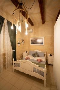 Un dormitorio con una cama y una lámpara de araña. en House Of Sliema - 4BR Traditional Townhouse, en Sliema