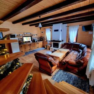 a living room with a leather couch and a table at Czirják Kulcsosház in Bucsin