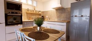 a kitchen with a table with chairs and a refrigerator at Gîte La Petite Lochoise in Loches