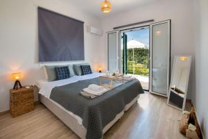 sypialnia z dużym łóżkiem i dużym oknem w obiekcie Dream view apartments w mieście Lákka