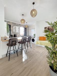 a kitchen and living room with chairs and a bed at Figueirinha - Sunset Room in Campanário