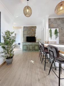 a living room with a table and chairs and a television at Figueirinha - Sunset Room in Campanário
