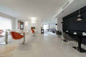 un comedor con mesas, sillas y una pared en Corte Ongaro Hotel, en Verona