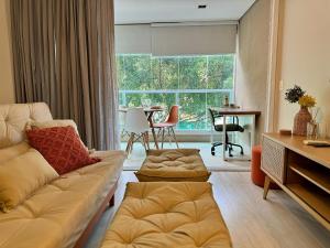 a living room with a couch and a large window at Praça Madá - Anystay in Sao Paulo
