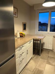 a kitchen with a counter with a table and a refrigerator at Apartment T3 in Billère