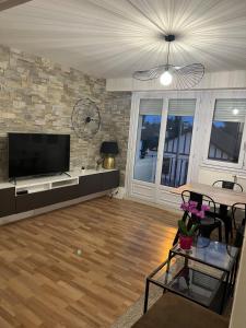a living room with a flat screen tv and a table at Apartment T3 in Billère