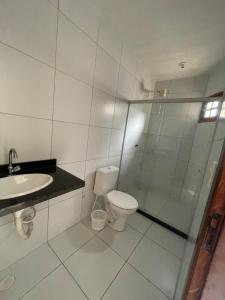 a bathroom with a shower and a toilet and a sink at Chã Grande - Cantinho Premium in Chã Grande +20 photos